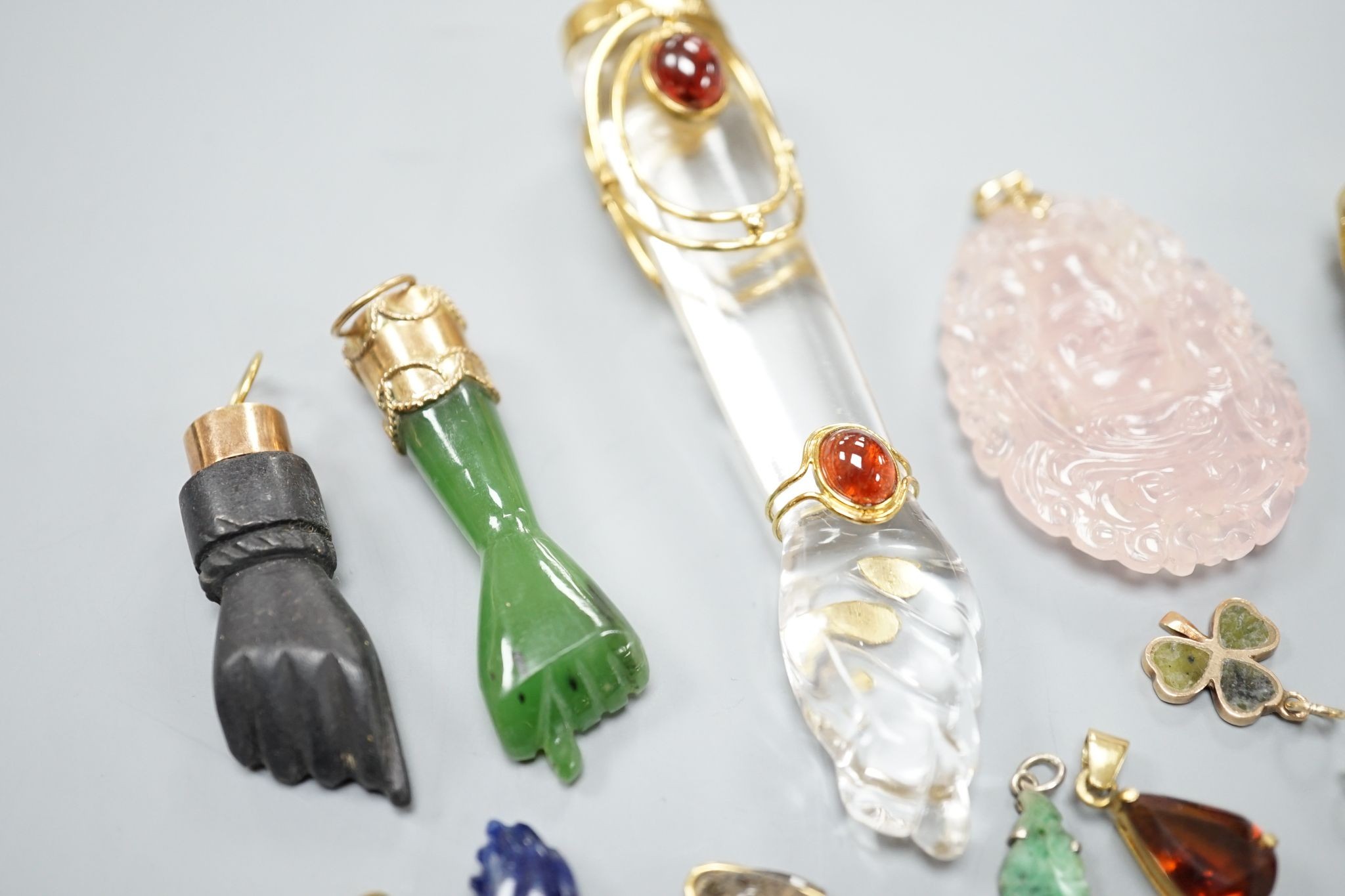 Seven assorted yellow metal or gilt metal mounted clasped hand charm or pendants, largest, 94mm, and seven other smaller charms/pendants including 14k and red enamel heart and an enamelled articulated fish.
